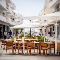 Terrazas de restaurantes en El Médano junto a una calle peatonal y viviendas